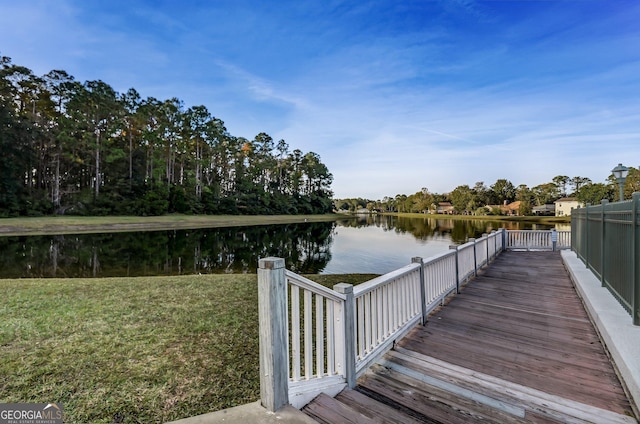 view of dock featuring a water view and a lawn