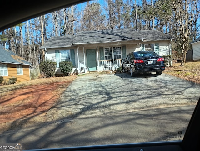 single story home with covered porch and aphalt driveway