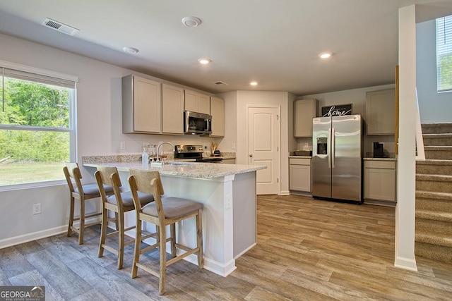 kitchen featuring sink, gray cabinetry, stainless steel appliances, light hardwood / wood-style floors, and kitchen peninsula