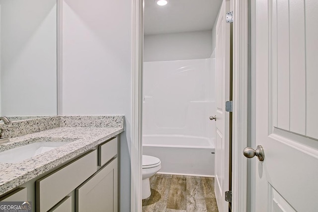 full bathroom with vanity, wood-type flooring, tub / shower combination, and toilet