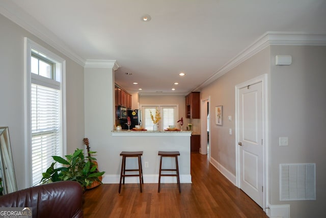 6422 Paulson, Atlanta, GA 30328 - kitchen with visible vents, dark wood-style floors, ornamental molding, stainless steel microwave, and freestanding refrigerator
