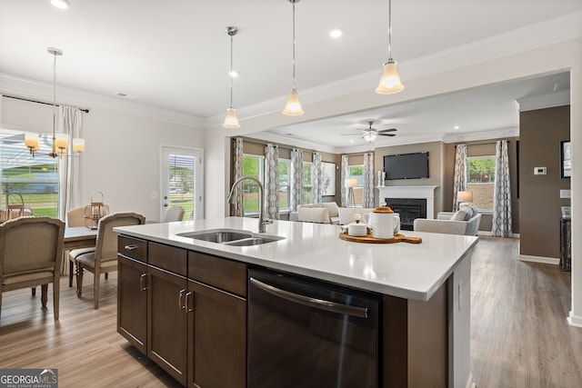 kitchen featuring pendant lighting, sink, dishwasher, a kitchen island with sink, and dark brown cabinets