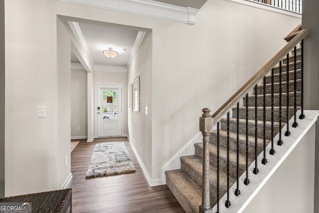 foyer entrance with ornamental molding and dark hardwood / wood-style flooring