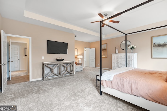 bedroom featuring a tray ceiling and light carpet