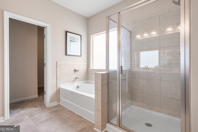 bathroom with tile patterned flooring and separate shower and tub