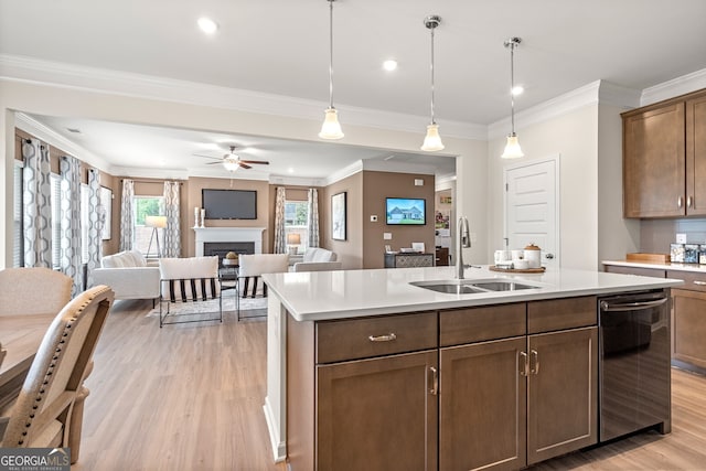 kitchen featuring sink, light wood-type flooring, dishwasher, an island with sink, and pendant lighting