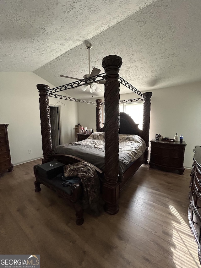 bedroom featuring lofted ceiling, dark hardwood / wood-style floors, and a textured ceiling