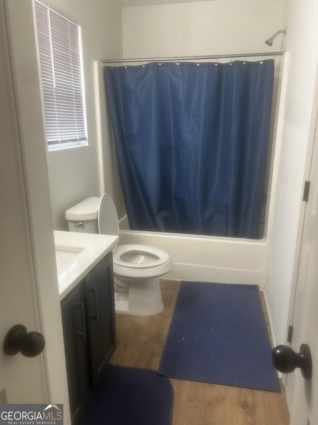 full bathroom with vanity, wood-type flooring, toilet, and shower / bath combo with shower curtain