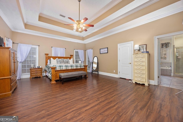 bedroom with a tray ceiling, dark wood-type flooring, and ornamental molding