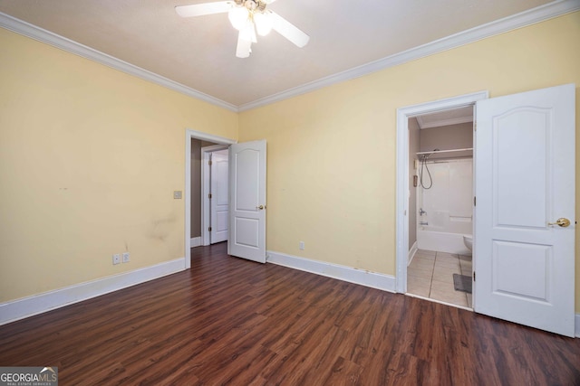 unfurnished bedroom with crown molding, ensuite bath, ceiling fan, and dark wood-type flooring