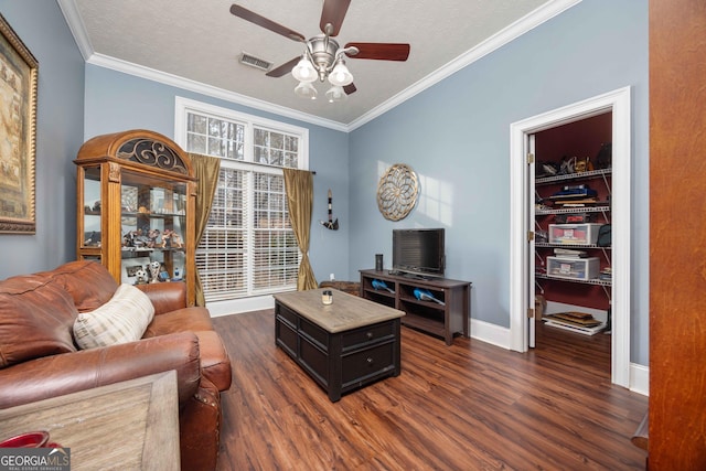 living room with crown molding, ceiling fan, and dark hardwood / wood-style flooring