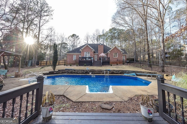 view of swimming pool with a wooden deck and a diving board