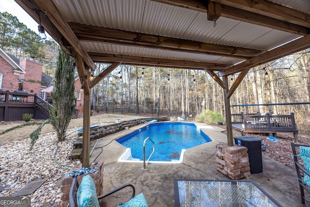 view of swimming pool with a patio and a deck