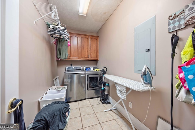 laundry area featuring cabinets, electric panel, washer and dryer, and a textured ceiling