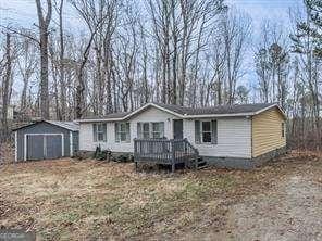 view of front of home with a shed and a deck