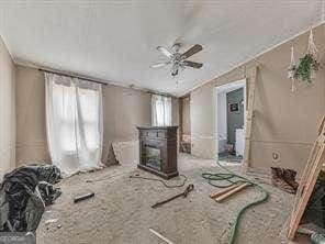 miscellaneous room featuring ceiling fan and a fireplace