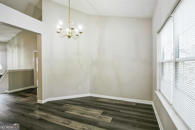 unfurnished dining area featuring lofted ceiling, dark hardwood / wood-style floors, and an inviting chandelier