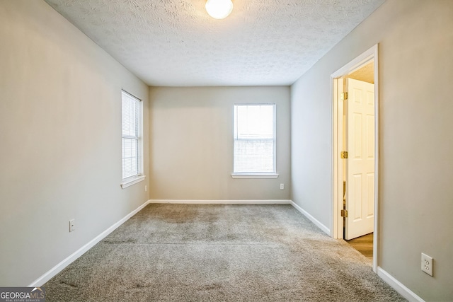 carpeted empty room with a textured ceiling