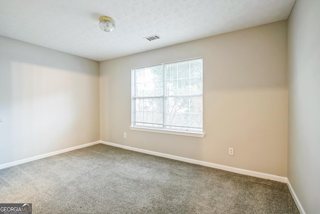 carpeted spare room with a textured ceiling