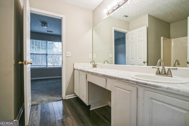 bathroom with vanity, hardwood / wood-style flooring, and a textured ceiling