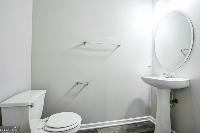 bathroom with hardwood / wood-style floors and toilet