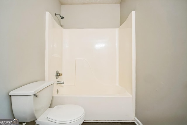 bathroom with bathing tub / shower combination, a textured ceiling, and toilet