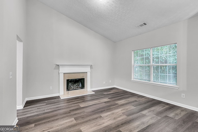 unfurnished living room with hardwood / wood-style flooring, lofted ceiling, and a textured ceiling