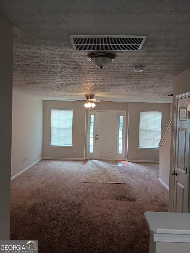 entryway with carpet floors, a healthy amount of sunlight, and visible vents