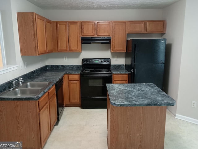 kitchen featuring black appliances, dark countertops, a sink, and under cabinet range hood