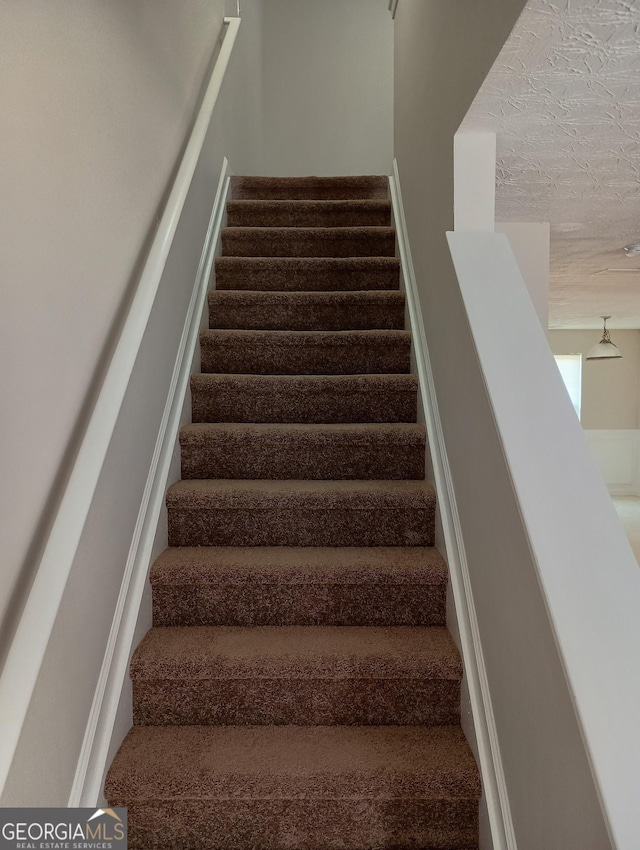 stairway with a textured ceiling