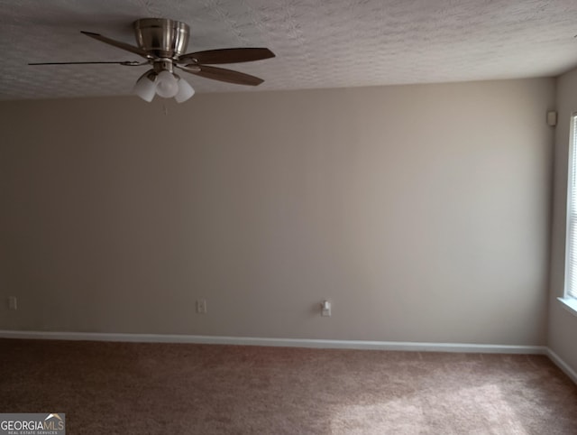 carpeted spare room featuring ceiling fan, baseboards, and a textured ceiling