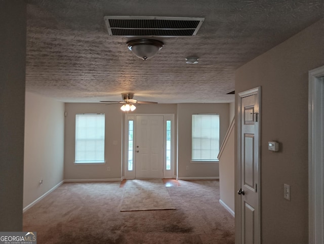 carpeted entryway with plenty of natural light, visible vents, and baseboards