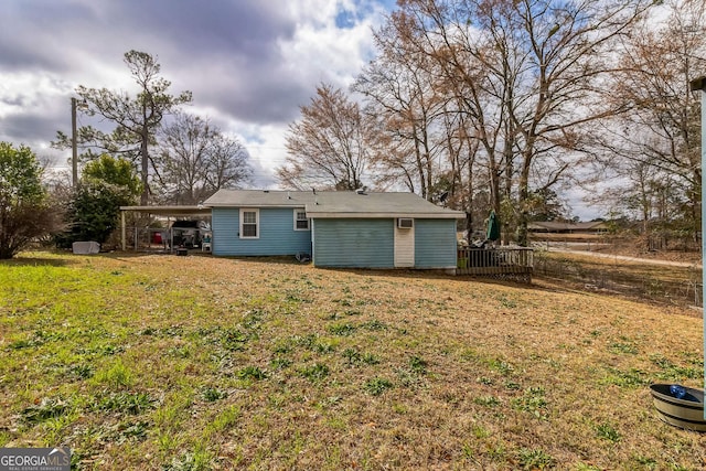 back of house with a lawn and a carport