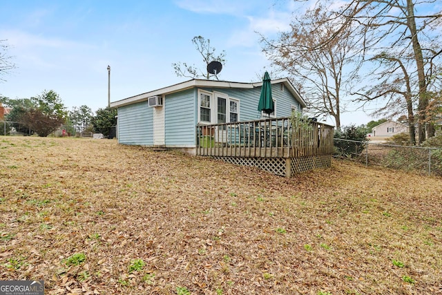 back of property featuring a wooden deck, a lawn, and a wall mounted AC