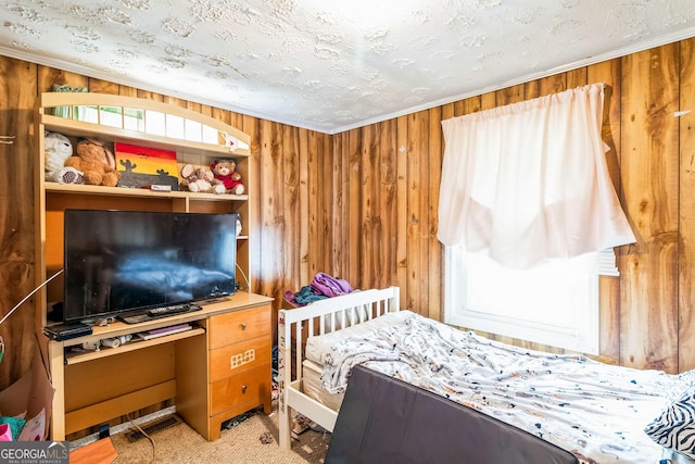 bedroom featuring multiple windows, crown molding, a textured ceiling, and wooden walls