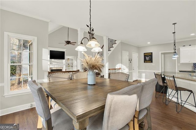 dining room featuring dark wood-style floors, a fireplace, stairway, and baseboards