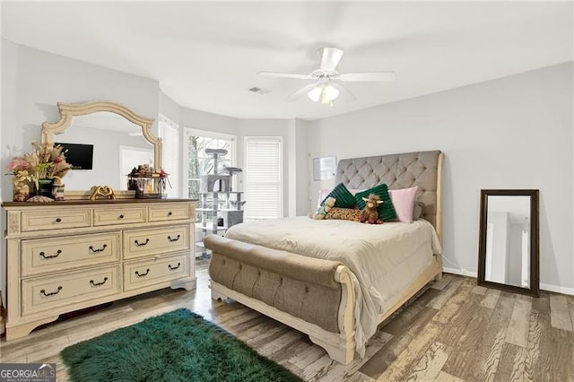 bedroom featuring light wood-style flooring, visible vents, baseboards, and a ceiling fan