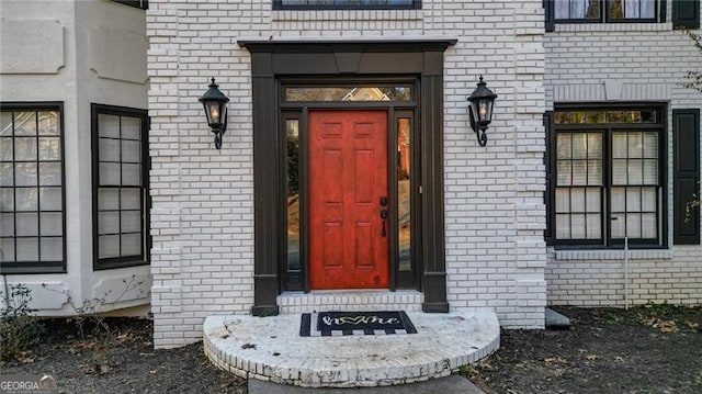 view of exterior entry with brick siding