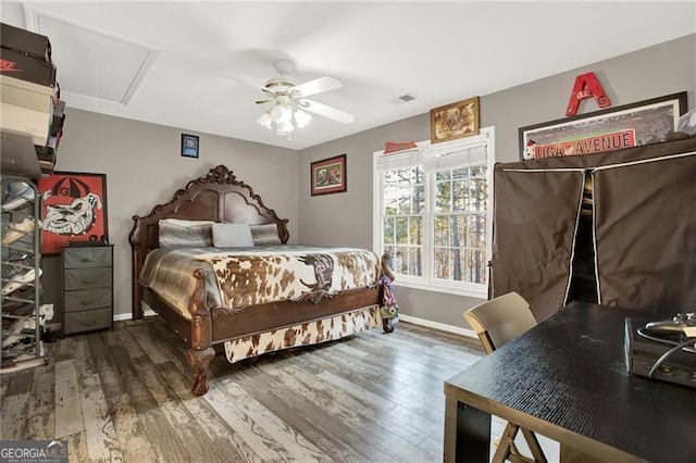 bedroom featuring ceiling fan, dark wood-type flooring, attic access, and baseboards