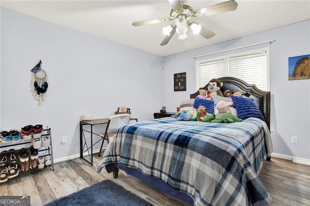 bedroom with ceiling fan, baseboards, and wood finished floors