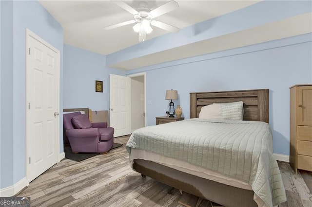 bedroom with ceiling fan, baseboards, and wood finished floors