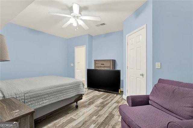 bedroom with light wood-type flooring, visible vents, and a ceiling fan