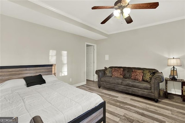 bedroom with baseboards, ornamental molding, ceiling fan, and wood finished floors