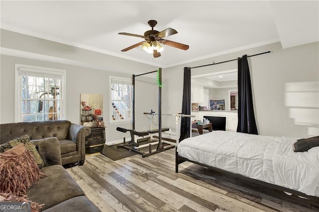 bedroom with ornamental molding, ceiling fan, and wood finished floors