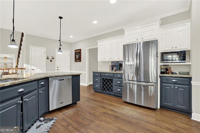 kitchen with stainless steel appliances, dark wood-style flooring, white cabinetry, and hanging light fixtures