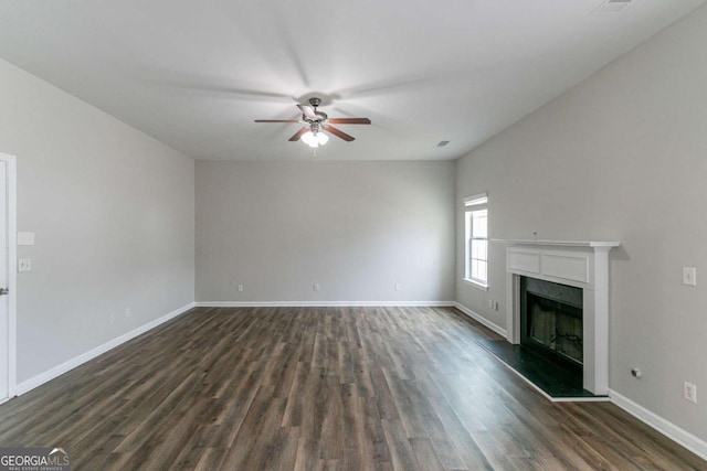 unfurnished living room featuring dark hardwood / wood-style flooring, a high end fireplace, and ceiling fan