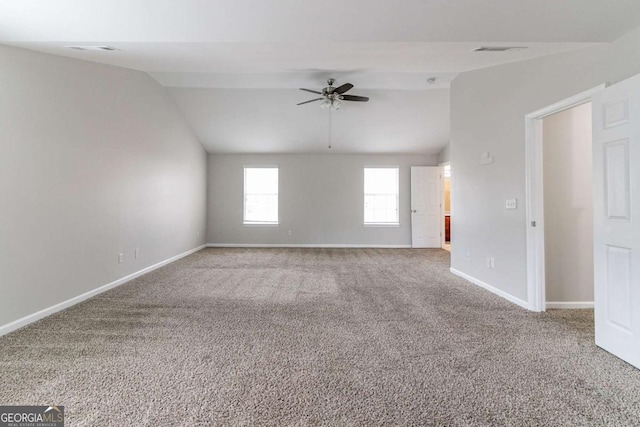 carpeted spare room with ceiling fan and vaulted ceiling