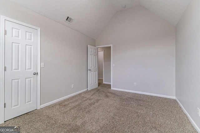 unfurnished bedroom with vaulted ceiling and carpet