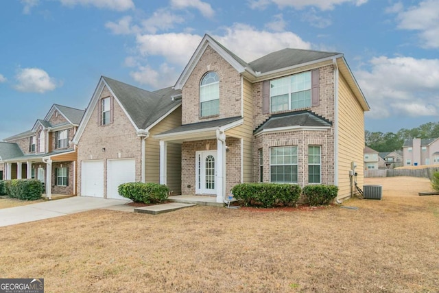 view of property with a garage, central AC unit, and a front lawn