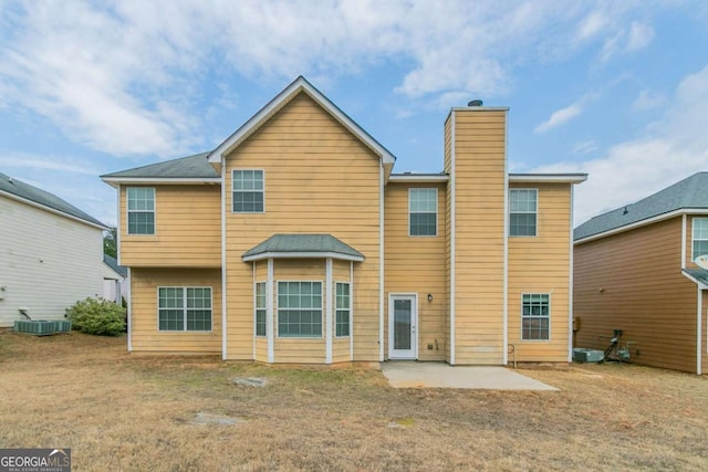 rear view of house with a lawn, cooling unit, and a patio area